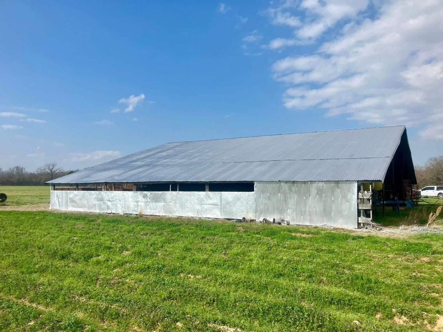 The same long barn with its whole roof coated silver